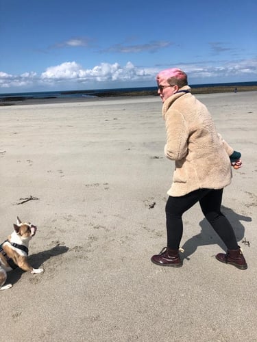 Senior Marketing Executive, Camille Brouard with her dog Bo on the beach in Guernsey